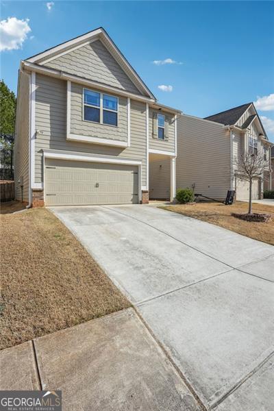 view of front of house with a garage, brick siding, and concrete driveway