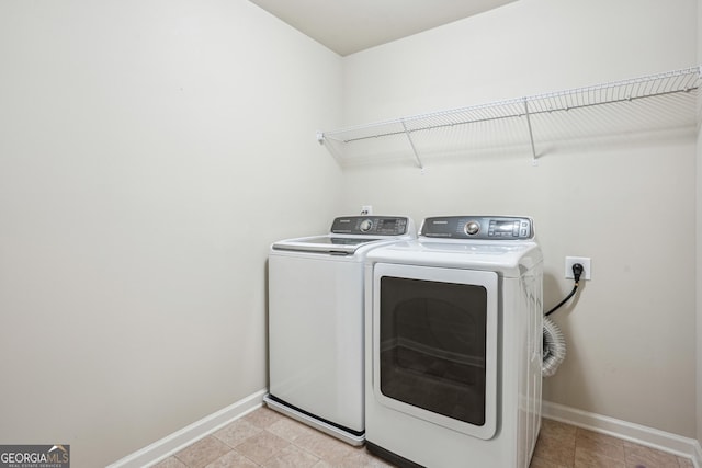 laundry area featuring baseboards, washing machine and dryer, and laundry area