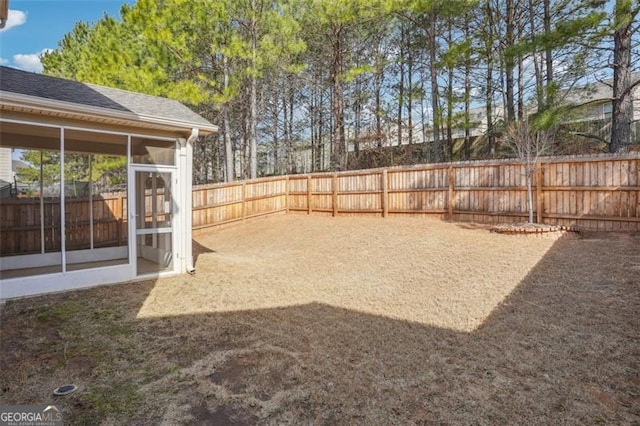 view of yard featuring a fenced backyard and a sunroom