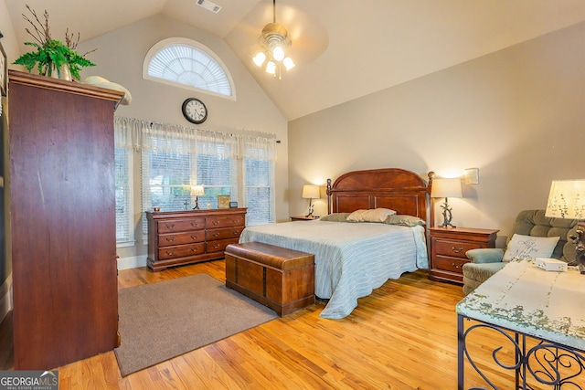 bedroom featuring visible vents, high vaulted ceiling, and wood finished floors