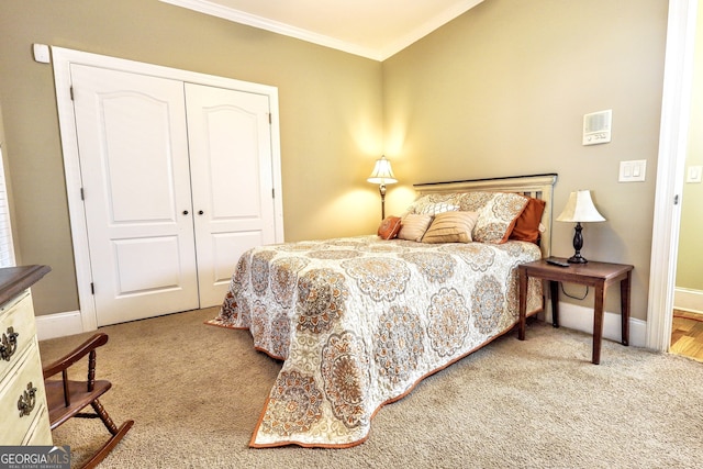 bedroom featuring a closet, carpet flooring, crown molding, and baseboards