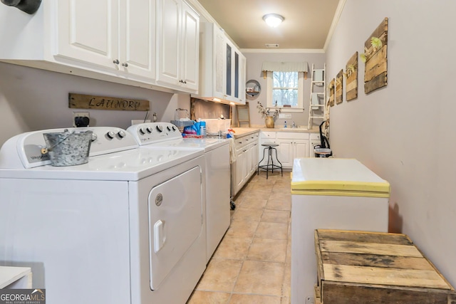 laundry room featuring washing machine and clothes dryer, ornamental molding, light tile patterned floors, cabinet space, and a sink