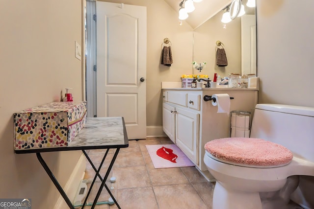 bathroom with baseboards, toilet, vanity, and tile patterned flooring