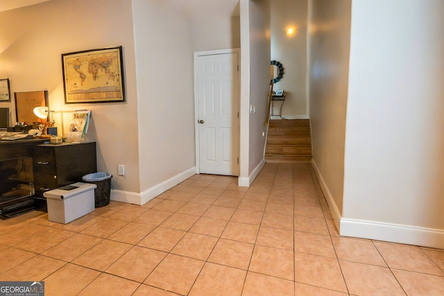 hall with light tile patterned flooring and baseboards