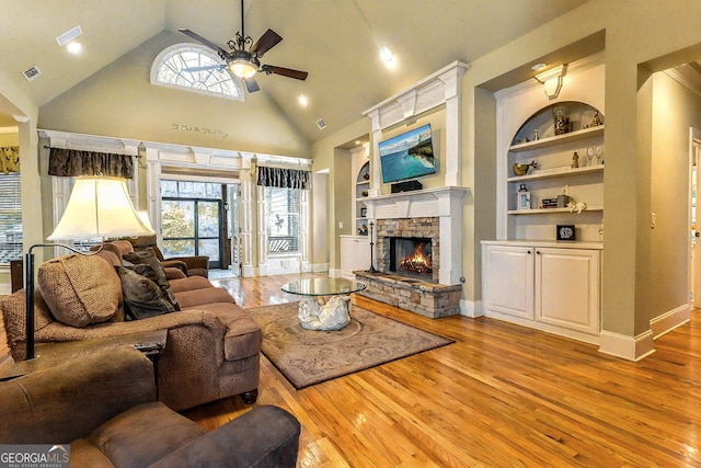 living area with plenty of natural light, built in shelves, and ceiling fan