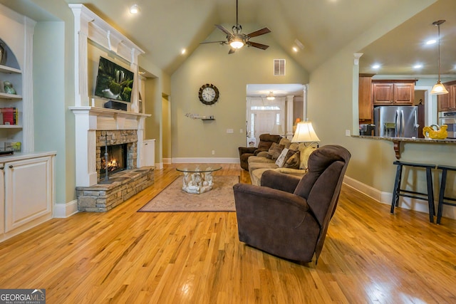 living room with visible vents, high vaulted ceiling, a ceiling fan, light wood-style floors, and a fireplace