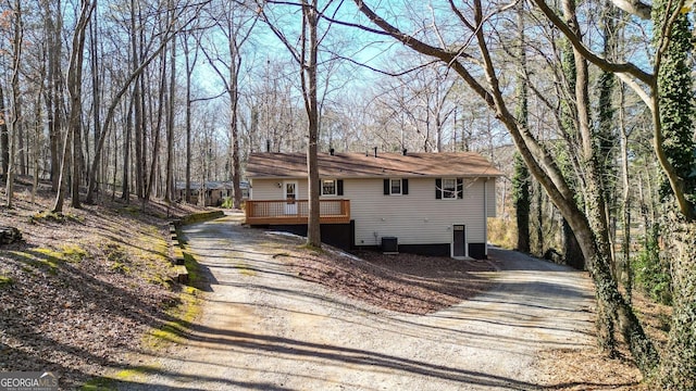 view of front facade with a deck, driveway, and central AC