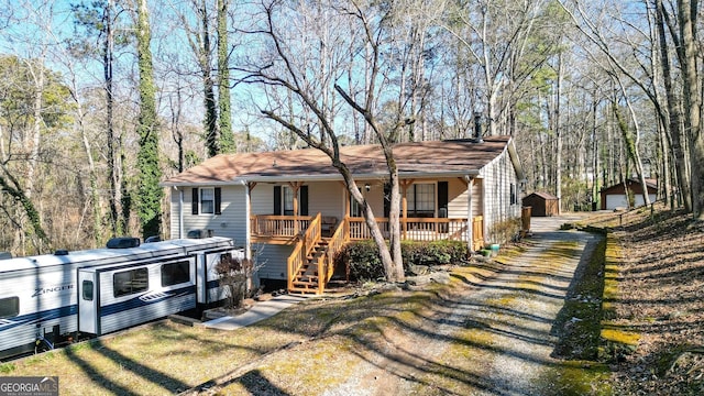 view of front of home with covered porch and an outdoor structure