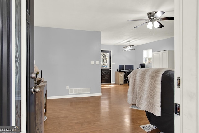 entrance foyer featuring visible vents, baseboards, wood finished floors, and a ceiling fan