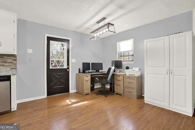 home office with baseboards and wood finished floors