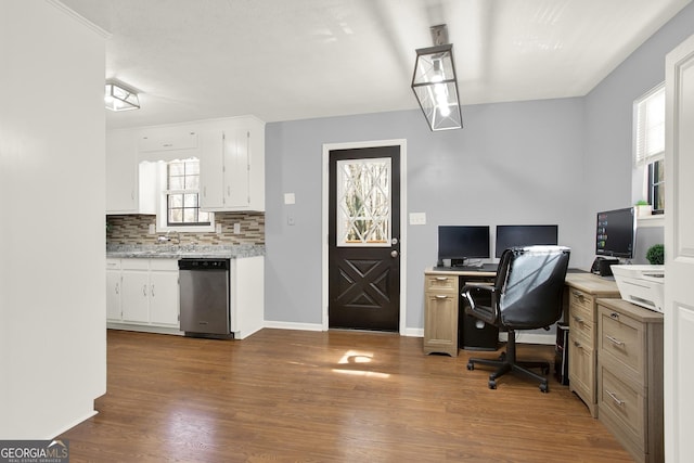 office area with dark wood-type flooring, baseboards, and a sink