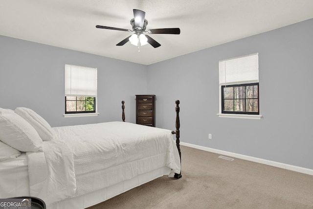 carpeted bedroom featuring visible vents, baseboards, and ceiling fan