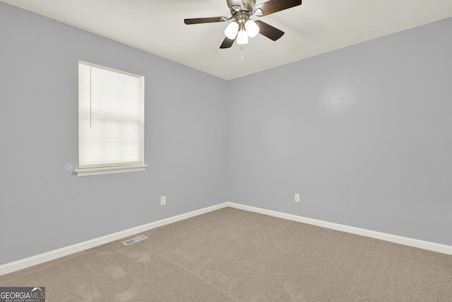 carpeted empty room featuring a ceiling fan, baseboards, and visible vents