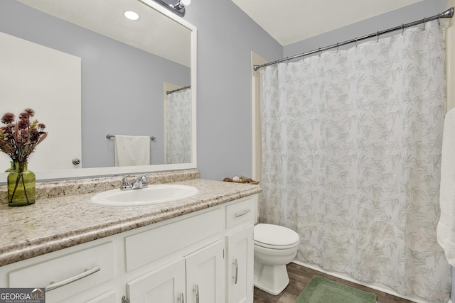 full bath featuring toilet, vanity, and wood finished floors