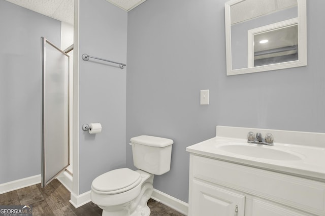 full bath with vanity, wood finished floors, baseboards, a stall shower, and toilet