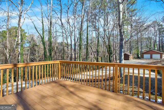 wooden deck with a garage and an outdoor structure