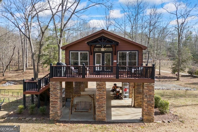 rear view of property with a deck and a patio area