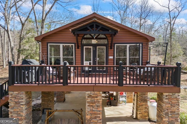 rear view of property featuring faux log siding and a deck