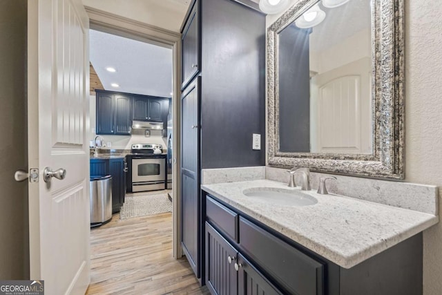 bathroom featuring vanity, recessed lighting, and wood finished floors