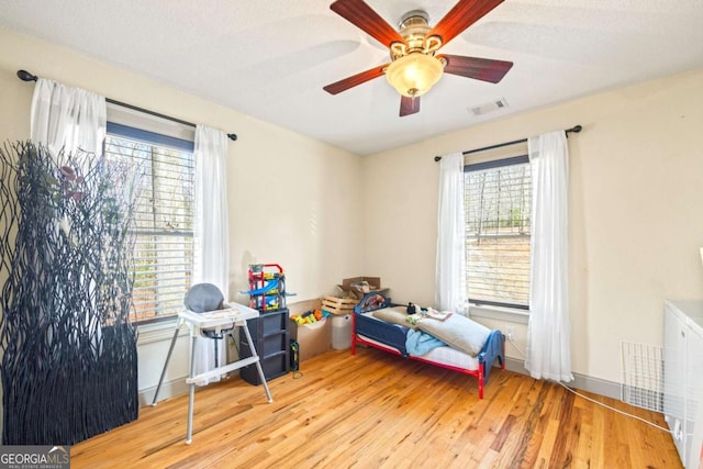 bedroom featuring visible vents, a ceiling fan, and wood finished floors