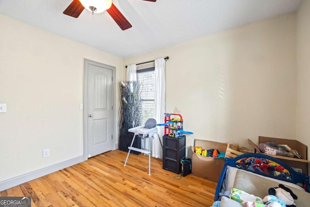 game room with wood finished floors, baseboards, and ceiling fan