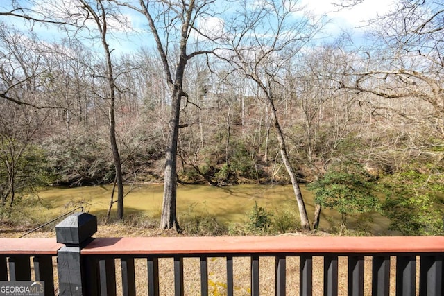 view of yard featuring a forest view and a water view