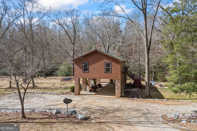 view of front of property featuring a carport, driveway, and stairs