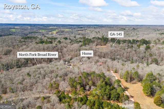 birds eye view of property featuring a wooded view