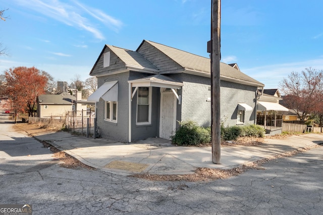 view of front of home with brick siding and fence