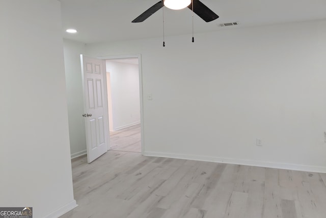 unfurnished room with light wood finished floors, visible vents, ceiling fan, and baseboards