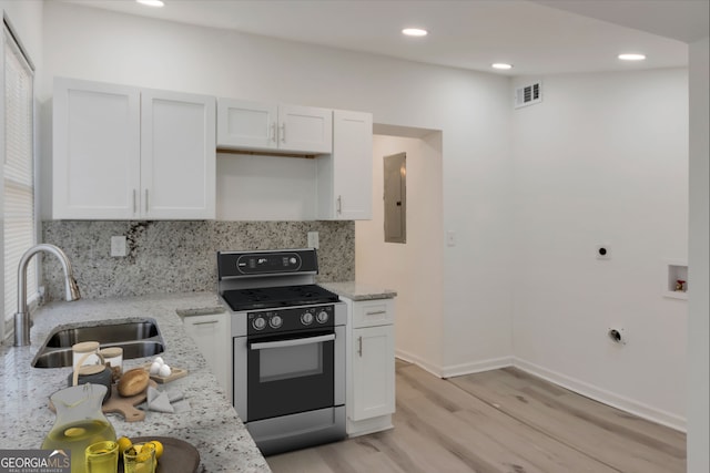 kitchen featuring visible vents, white cabinetry, a sink, range with gas cooktop, and tasteful backsplash