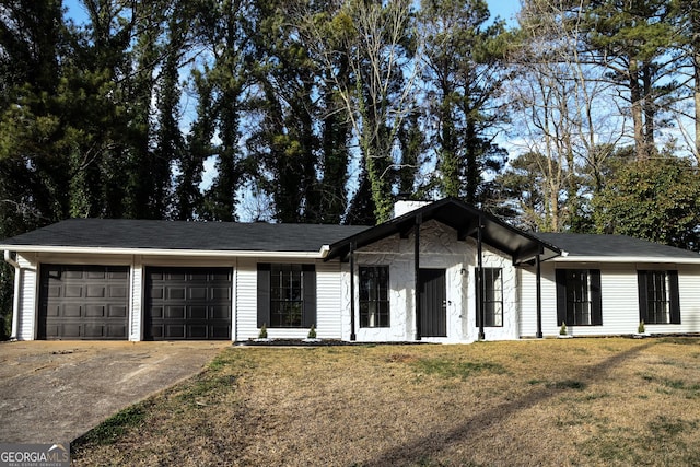 view of front of home featuring a front lawn, an attached garage, and driveway