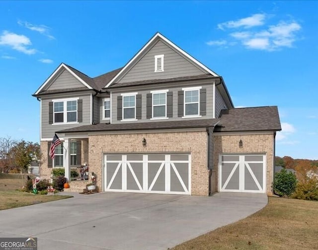 view of front of house featuring concrete driveway, a garage, brick siding, and a front yard