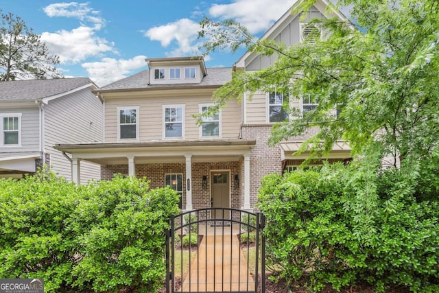 view of front of house featuring brick siding and a gate