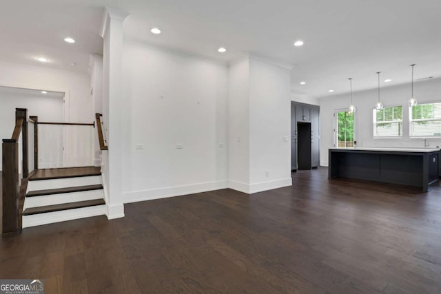 unfurnished living room featuring stairs, dark wood-type flooring, recessed lighting, and baseboards