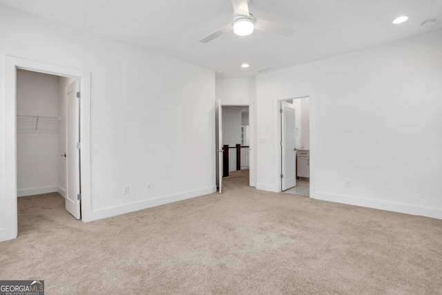 unfurnished bedroom featuring recessed lighting, a walk in closet, baseboards, and carpet flooring