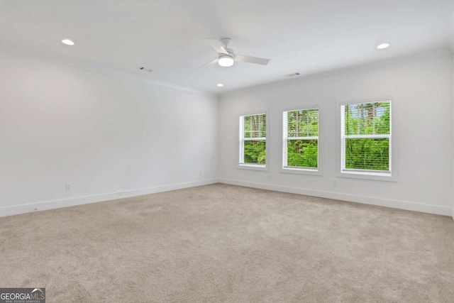 unfurnished room with recessed lighting, baseboards, plenty of natural light, and light colored carpet