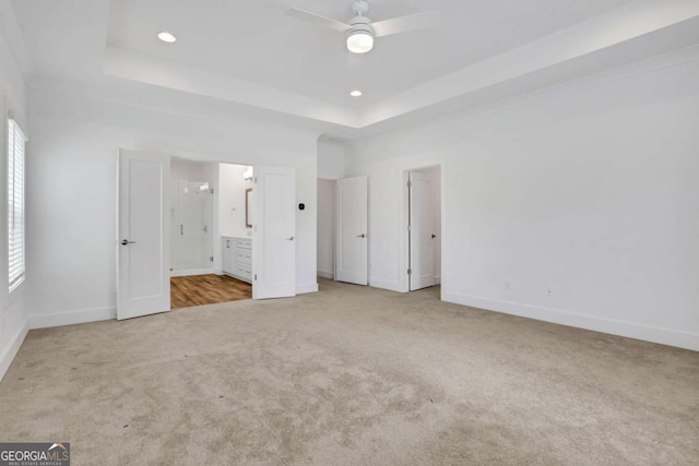 unfurnished bedroom featuring carpet, baseboards, recessed lighting, a raised ceiling, and connected bathroom