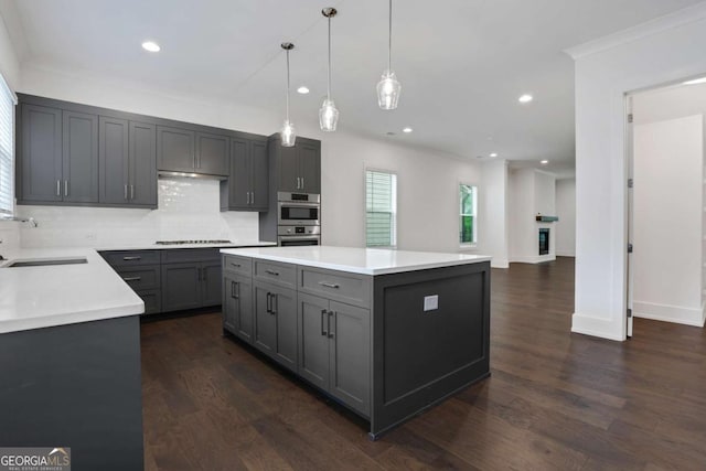 kitchen with dark wood-style floors, gray cabinets, stovetop, and a sink