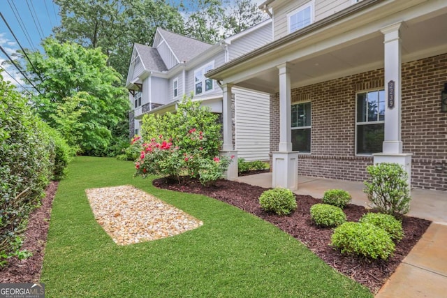 exterior space with brick siding and a yard