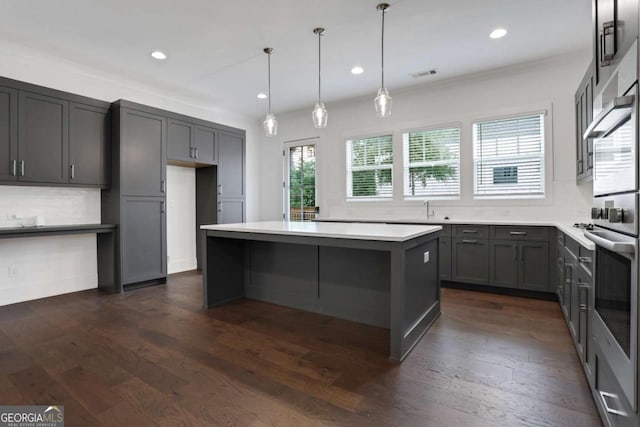 kitchen featuring tasteful backsplash, visible vents, a center island, stainless steel oven, and dark wood-style flooring