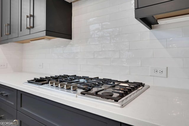 interior details featuring tasteful backsplash, stainless steel gas stovetop, gray cabinets, and light countertops