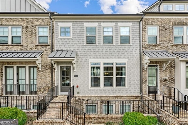 townhome / multi-family property featuring a standing seam roof and metal roof