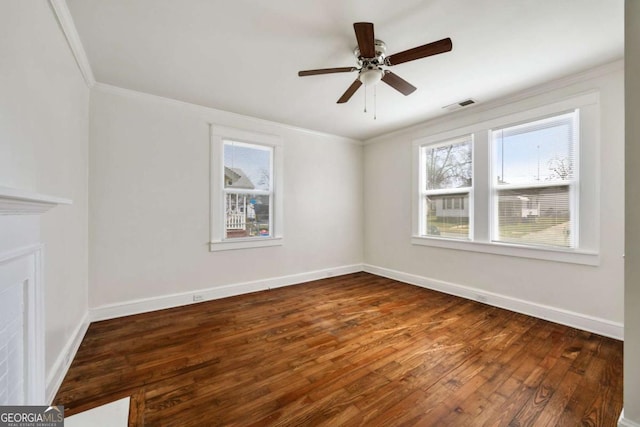 unfurnished room with a ceiling fan, visible vents, crown molding, wood finished floors, and baseboards