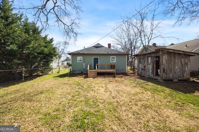 back of house with an outdoor structure, fence, a yard, and a wooden deck