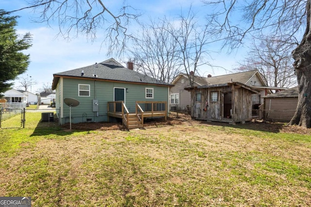 rear view of property with a yard, an outdoor structure, fence, and a gate