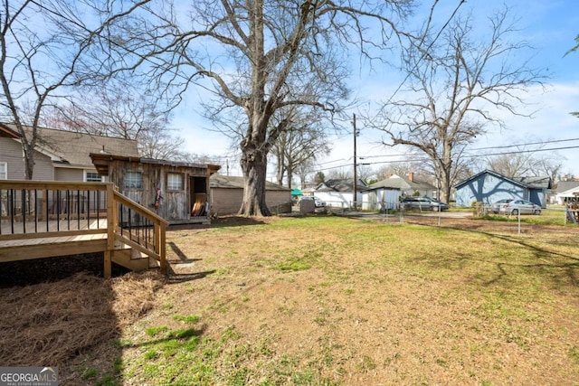 view of yard featuring a wooden deck, a residential view, and fence
