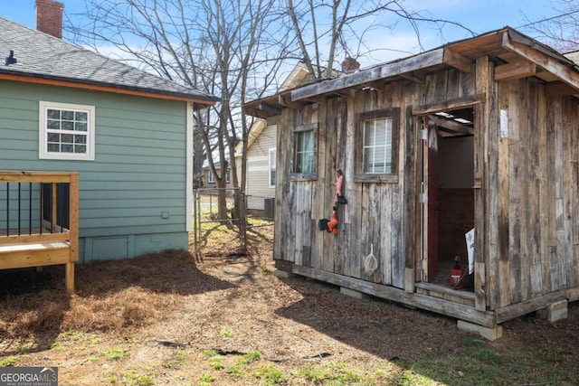 view of outbuilding featuring fence and an outbuilding