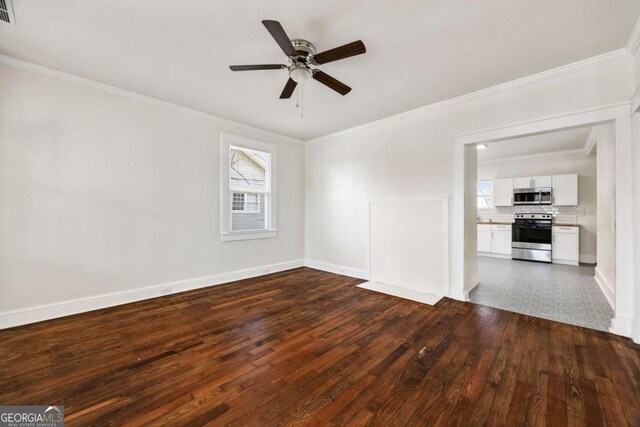 spare room with ornamental molding, a ceiling fan, baseboards, visible vents, and dark wood-style floors