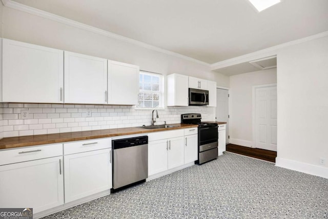 kitchen with white cabinets, a sink, wood counters, backsplash, and stainless steel appliances
